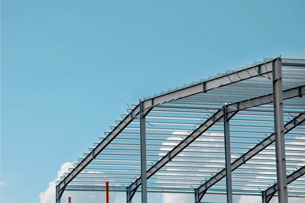 imagem de um galpão ao ar livre, o galpão é feito por estruturas metálicas de sustentação e um telhado em metal.